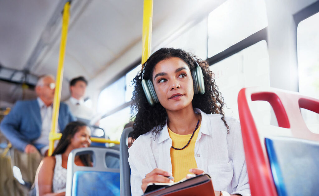 A woman with headphones on riding the bus