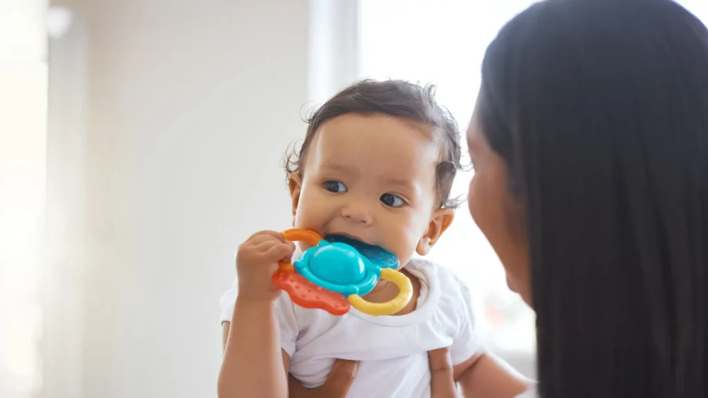 A baby chewing on a toy