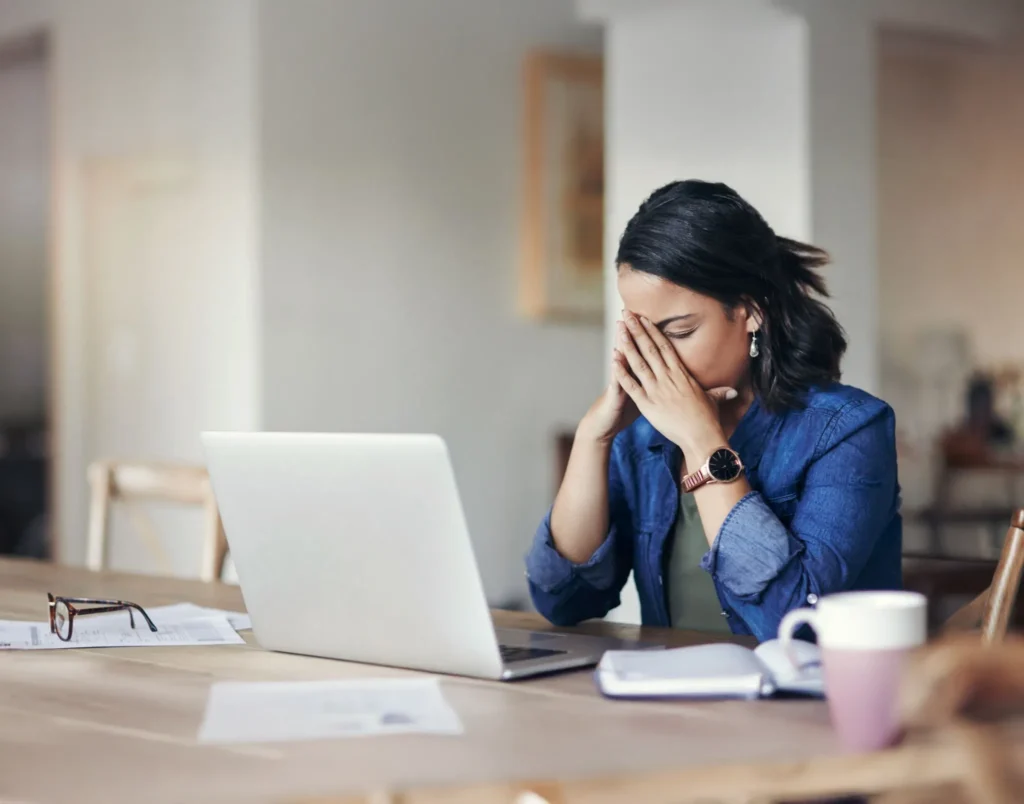 A woman stressed and sitting at a computer